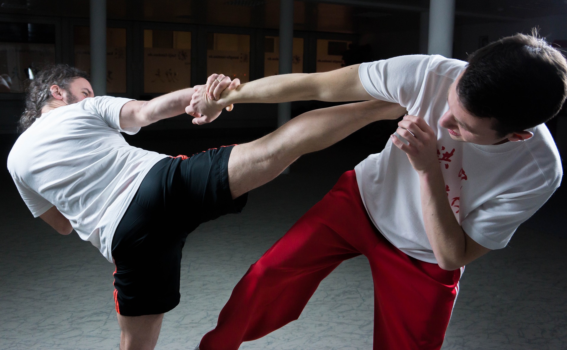 man kicking another man